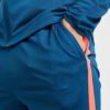 Running tracksuit with raglan sleeves, showing polyester texture. Partial zipper and visible stitching detail. Athletic wear.