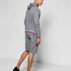 Sporty short tracksuit in bulk production. Ribbed knit trim, contrasting side stripes, close-up showing smooth, durable fabri