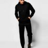 Slim athletic tracksuit. Close-up shows fine stitching, smooth fabric texture; hints of deep blues and charcoal grey. Streaml