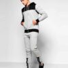 Skinny fit jogging tracksuit: panel design, custom cut and sew. Noticeable fabric texture, detailed stitching, athletic wear.