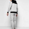Skinny fit jogging tracksuit: panel design, custom cut and sew. Noticeable fabric texture, detailed stitching, athletic wear.