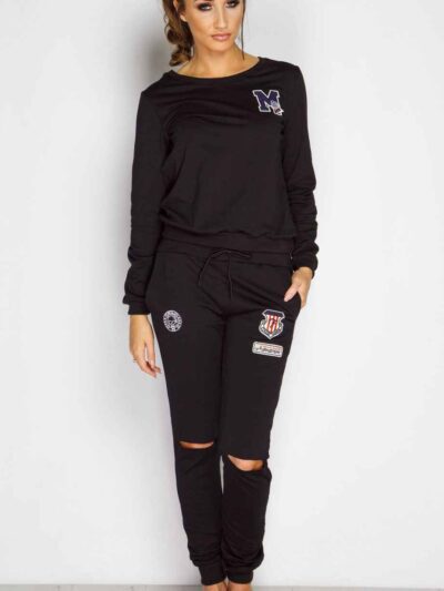 Black sweat suit with ripped knee detail, comfortable loungewear. Soft, textured fabric, visible stitching. Casual, stylish.