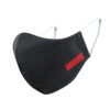 Close-up of a black face mask. Woven label detail. Finely stitched, durable fabric texture. Washable, reusable cloth face cov