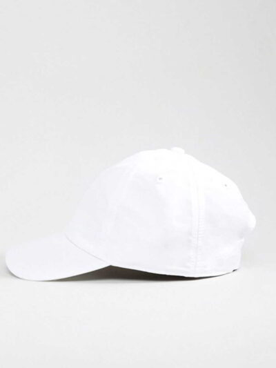Close-up of a blank polo cap in a light color. Notice the fine pique knit fabric texture and reinforced stitching details at