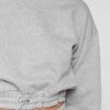 Woman in athletic tracksuit: heathered grey, comfy fit. Note the elastic cuffs, drawstring waist, and clean stitching. Active