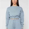 Woman in athletic tracksuit: heathered grey, comfy fit. Note the elastic cuffs, drawstring waist, and clean stitching. Active
