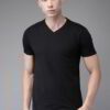 Folded stack of cotton tees. Assorted vibrant prints visible. Fine knit texture, even stitching. Short sleeve shirts, ready t