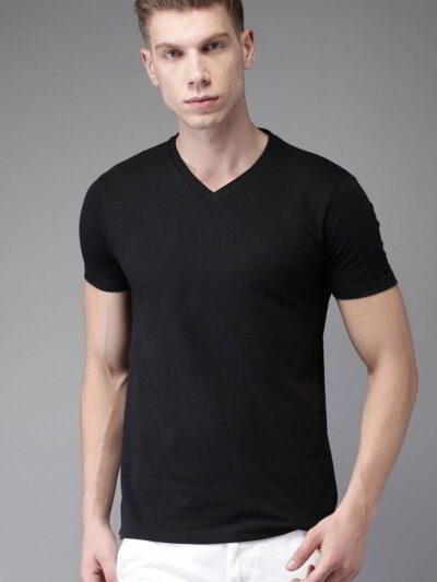Folded stack of cotton tees. Assorted vibrant prints visible. Fine knit texture, even stitching. Short sleeve shirts, ready t