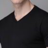 Folded stack of cotton tees. Assorted vibrant prints visible. Fine knit texture, even stitching. Short sleeve shirts, ready t