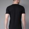 Folded stack of cotton tees. Assorted vibrant prints visible. Fine knit texture, even stitching. Short sleeve shirts, ready t