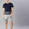 Heavyweight shorts, roomy fit. Textured fabric, robust stitching detail. Urban street style, likely cotton blend. Dark color,