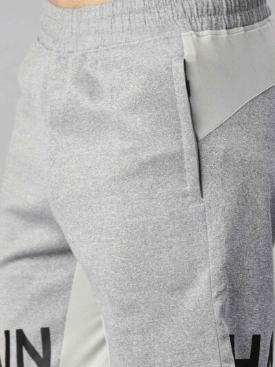 Heavyweight shorts, roomy fit. Textured fabric, robust stitching detail. Urban street style, likely cotton blend. Dark color,