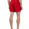 Lightweight summer beach shorts in a vibrant coral hue. Fine stitching detail shows durable construction. Soft, textured fabr