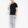 Close-up of neatly stacked tees. Soft cotton blend fabric, clean seams. Solid color assortment; hints of gray, navy, black. B