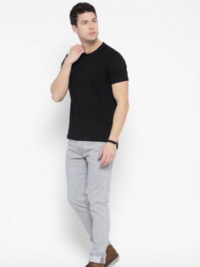 Close-up of neatly stacked tees. Soft cotton blend fabric, clean seams. Solid color assortment; hints of gray, navy, black. B