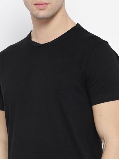 Close-up of neatly stacked tees. Soft cotton blend fabric, clean seams. Solid color assortment; hints of gray, navy, black. B