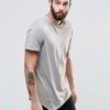 Close-up of vibrant red T-shirts stacked high. Soft cotton knit texture visible. Clean stitching detail. Wholesale garment qu