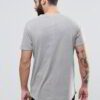 Close-up of vibrant red T-shirts stacked high. Soft cotton knit texture visible. Clean stitching detail. Wholesale garment qu