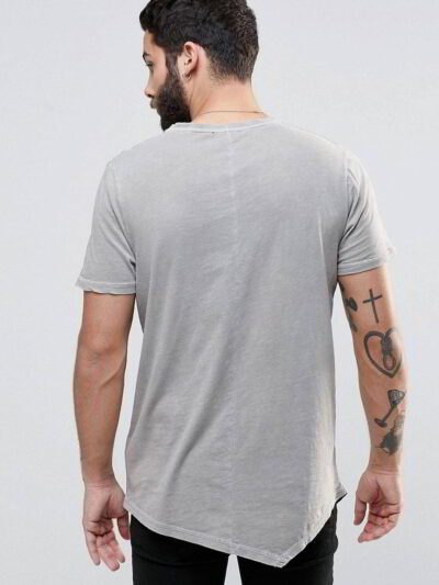 Close-up of vibrant red T-shirts stacked high. Soft cotton knit texture visible. Clean stitching detail. Wholesale garment qu