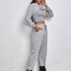 Women's fitness tracksuit and joggers set. Heather grey marl fabric, visible fine stitching. Soft, comfortable gym apparel.