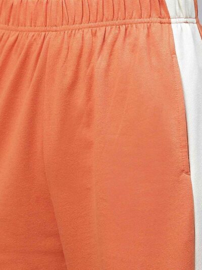 Velour tracksuit for women. Soft, plush texture. Note custom logo detail. Two-piece set in a rich, inviting hue. Quality stit