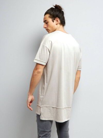 Stack of youth t-shirts. Soft cotton knit texture, clean seams. Various colors hinted: red, green, blue. Basic crewneck style