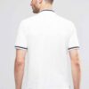 Close-up: Navy polo shirt. Fine pique knit texture, crisp collar, clean stitching. Custom logo embroidery. Professional appar