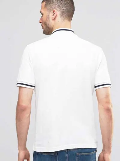 Close-up: Navy polo shirt. Fine pique knit texture, crisp collar, clean stitching. Custom logo embroidery. Professional appar