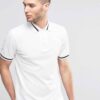 Close-up: Navy polo shirt. Fine pique knit texture, crisp collar, clean stitching. Custom logo embroidery. Professional appar