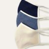 Close-up of a breathable cotton face mask. Soft fabric texture, neat stitching. Reusable face covering, light color, comforta