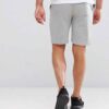 Athletic training shorts, close-up showing breathable woven fabric, reinforced stitching. Performance garment, likely navy or