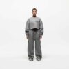 Ladies' two-piece tracksuit in soft-focus, muted color. Hooded zip jacket & wide-leg pants. Visible subtle stitching detail.