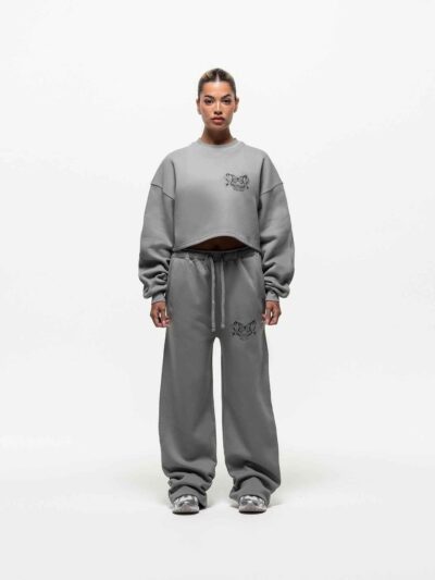 Ladies' two-piece tracksuit in soft-focus, muted color. Hooded zip jacket & wide-leg pants. Visible subtle stitching detail.