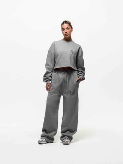 Ladies' two-piece tracksuit in soft-focus, muted color. Hooded zip jacket & wide-leg pants. Visible subtle stitching detail.