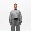 Ladies' two-piece tracksuit in soft-focus, muted color. Hooded zip jacket & wide-leg pants. Visible subtle stitching detail.