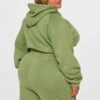 Close-up of a cotton women's tracksuit set in warm autumn hues. Soft, textured knit with detailed stitching. Relaxed fit, cus