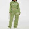 Close-up of a cotton women's tracksuit set in warm autumn hues. Soft, textured knit with detailed stitching. Relaxed fit, cus