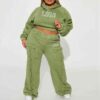 Close-up of a cotton women's tracksuit set in warm autumn hues. Soft, textured knit with detailed stitching. Relaxed fit, cus