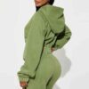 Close-up of a cotton women's tracksuit set in warm autumn hues. Soft, textured knit with detailed stitching. Relaxed fit, cus