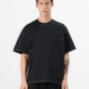 Black oversized t-shirt with contrast white stitching, drop shoulders, pocket. Soft, textured fabric. Custom logo imprint are