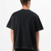 Black oversized t-shirt with contrast white stitching, drop shoulders, pocket. Soft, textured fabric. Custom logo imprint are