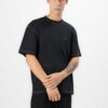 Black oversized t-shirt with contrast white stitching, drop shoulders, pocket. Soft, textured fabric. Custom logo imprint are