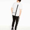 Men's stylish t-shirt, likely cotton. Close-up shows custom logo print. Fine stitching details on the navy blue collar and sl