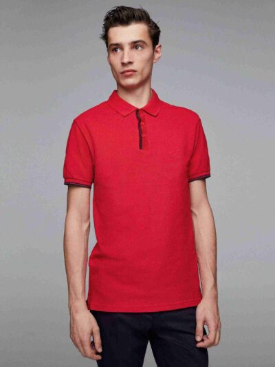 Close-up of a navy polo. Fine pique knit texture, crisp collar, clean three-button placket with reinforced stitching. Ideal g