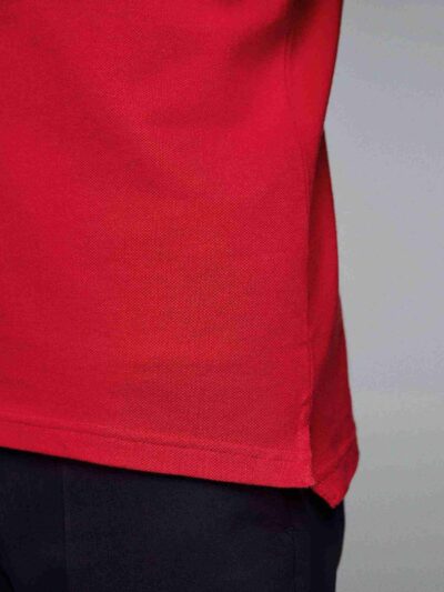 Close-up of a navy polo. Fine pique knit texture, crisp collar, clean three-button placket with reinforced stitching. Ideal g