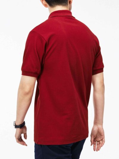 Close-up of hospitality polo shirt. Breathable knit fabric, fine stitching. Burgundy color with subtle contrast collar detail