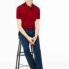 Close-up of hospitality polo shirt. Breathable knit fabric, fine stitching. Burgundy color with subtle contrast collar detail