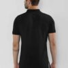 Close-up of a navy polo shirt, embroidered logo detail on chest, subtle pique knit texture, clean, precise stitching. - View