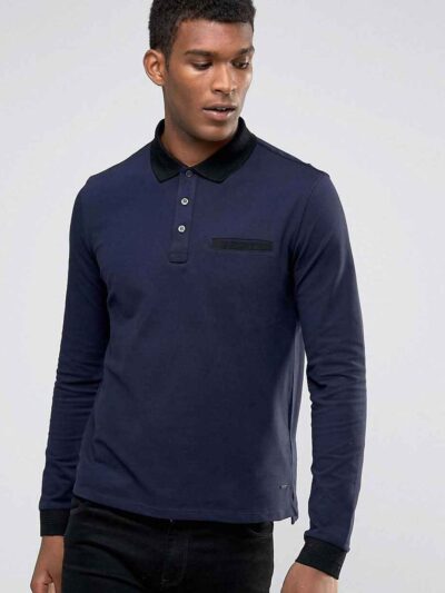 Close-up of a textured performance polo shirt. Fine stitching detail, breathable moisture-wicking fabric, a subtle blue hue.