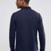 Close-up of a textured performance polo shirt. Fine stitching detail, breathable moisture-wicking fabric, a subtle blue hue.